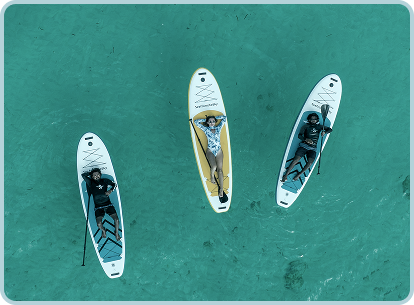 three paddleboards with people laying on them